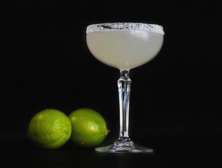 glass and limes on a black background